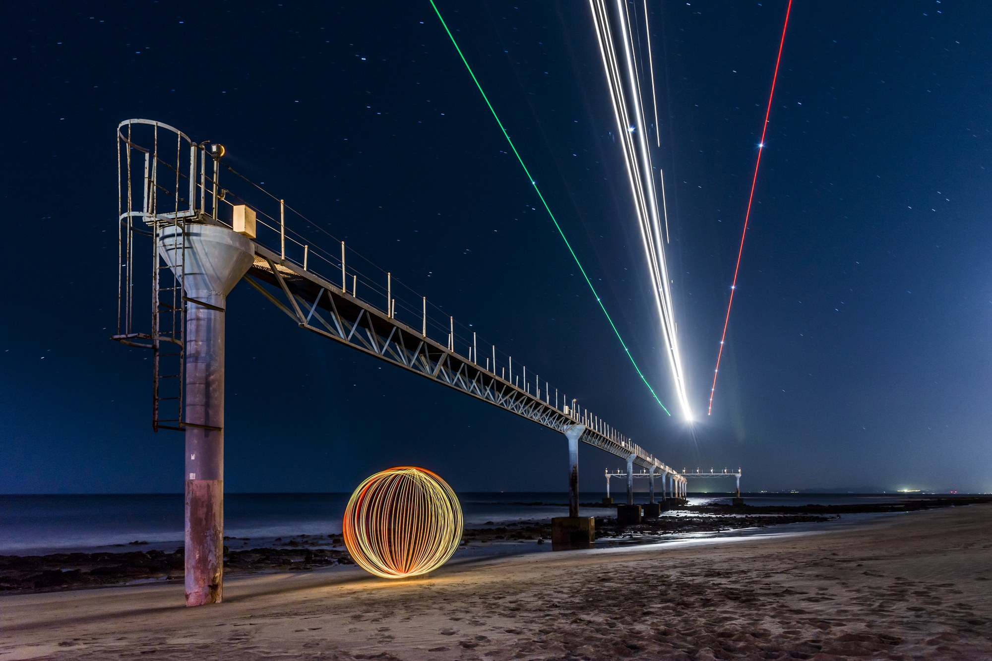 Esfera de luz y trazos luminosos junto a un muelle