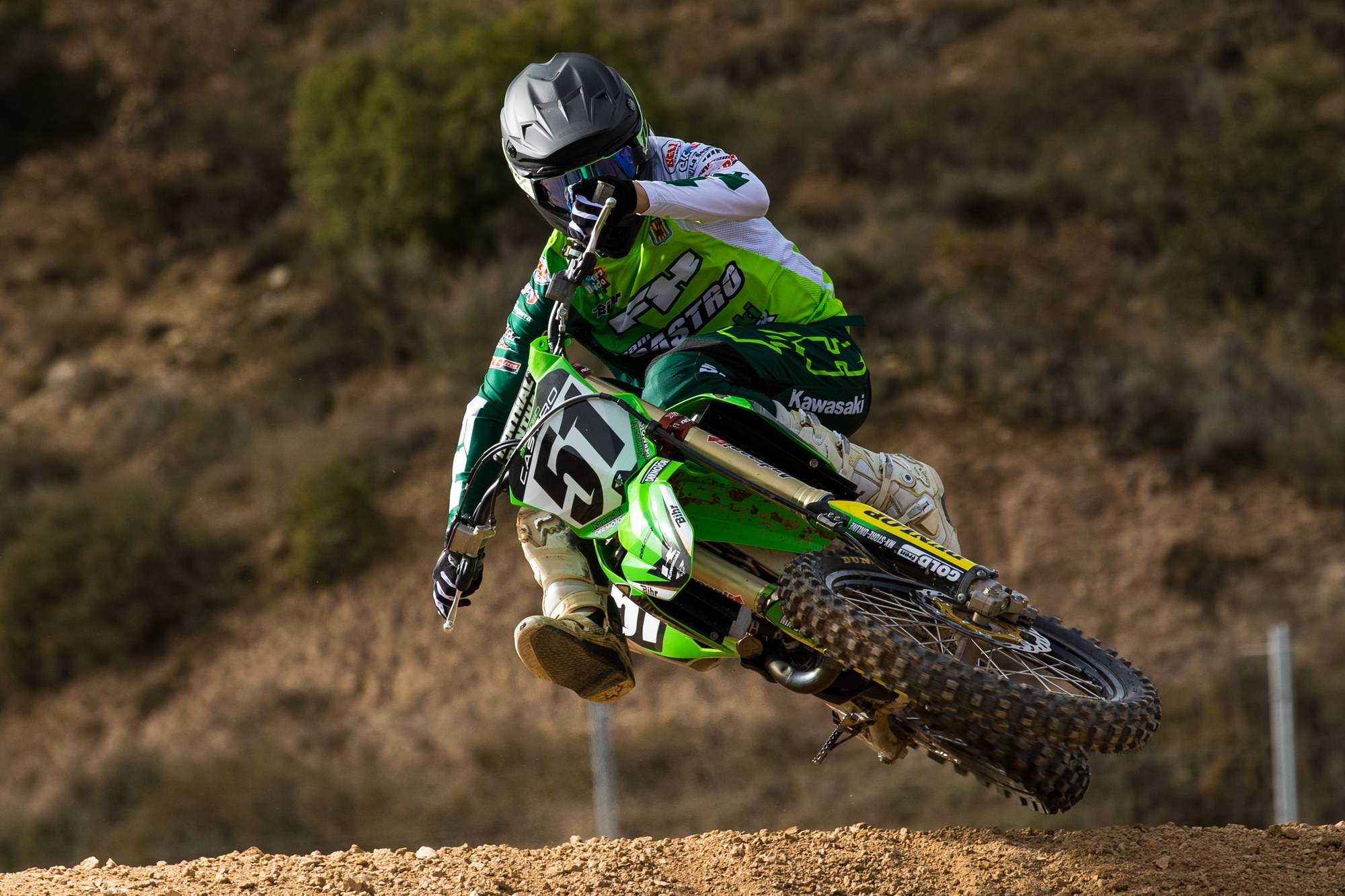 Piloto de motocross inclinado durante un salto