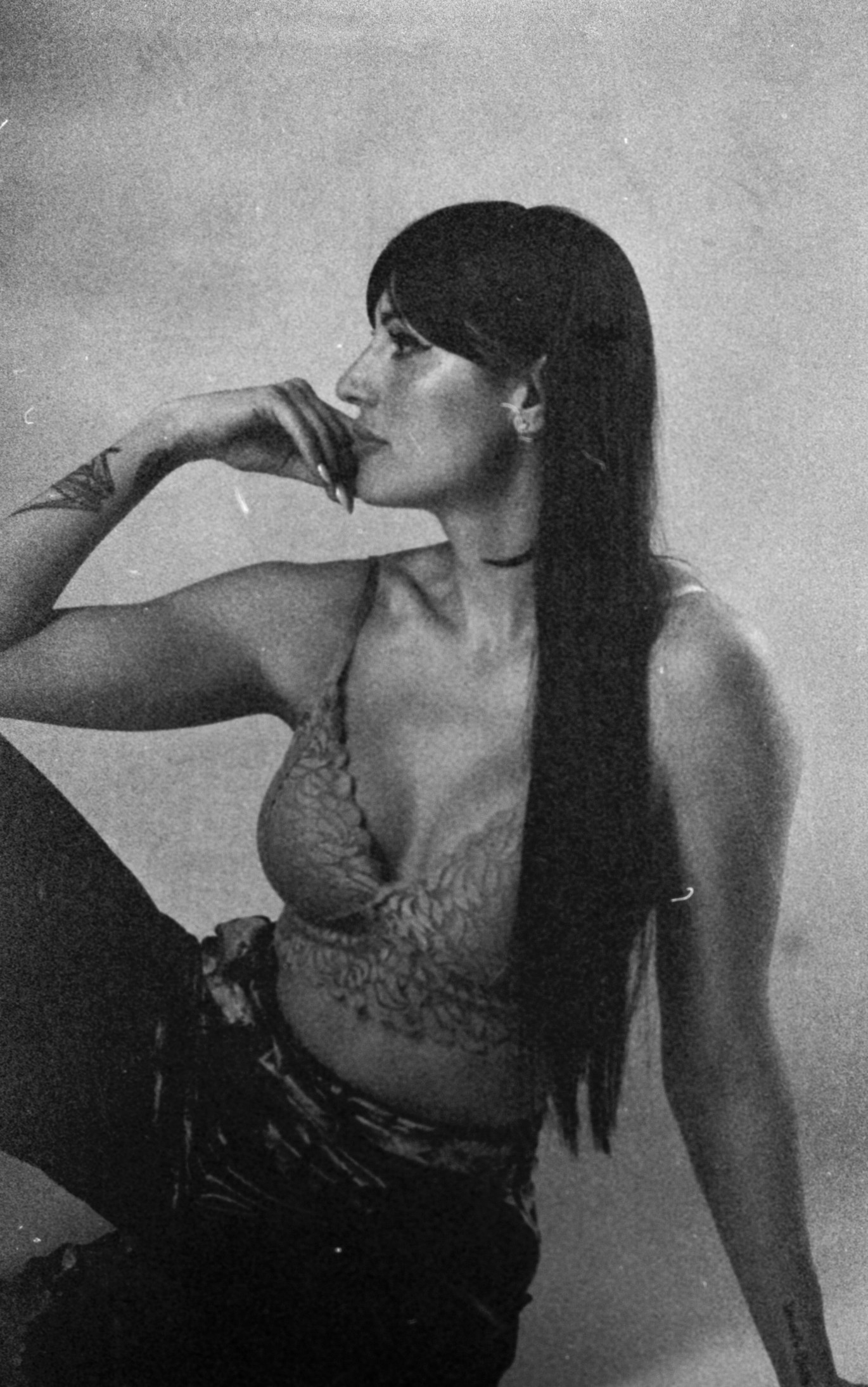 Retrato en blanco y negro de una mujer sentada de perfil con cabello largo
