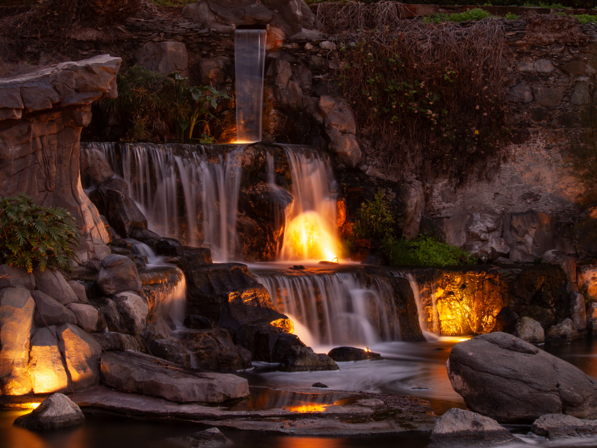 Cascada entre rocas iluminada con tonos cálidos