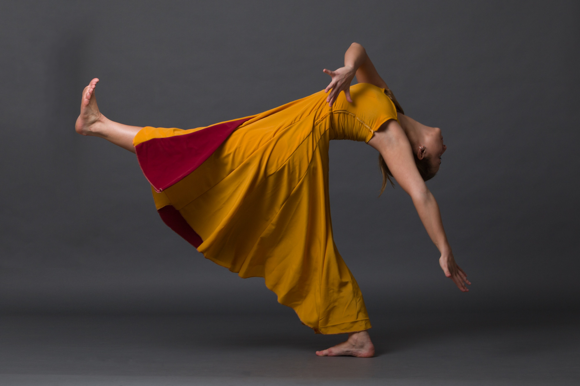 Dos bailarines entrelazados con un vestido amarillo en movimiento