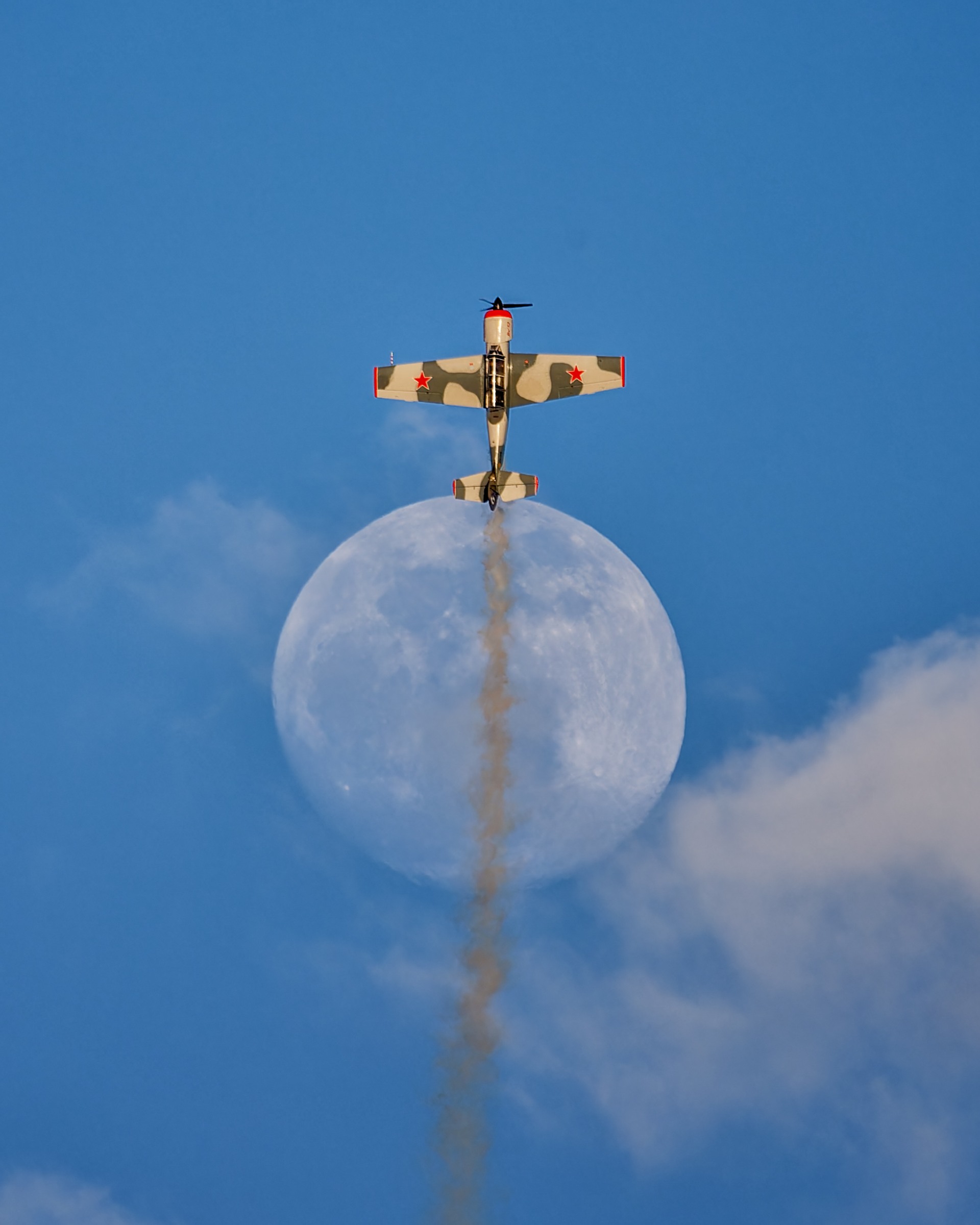 Avión alineado con la Luna en un cielo azul, fotografía de Chechu Senís