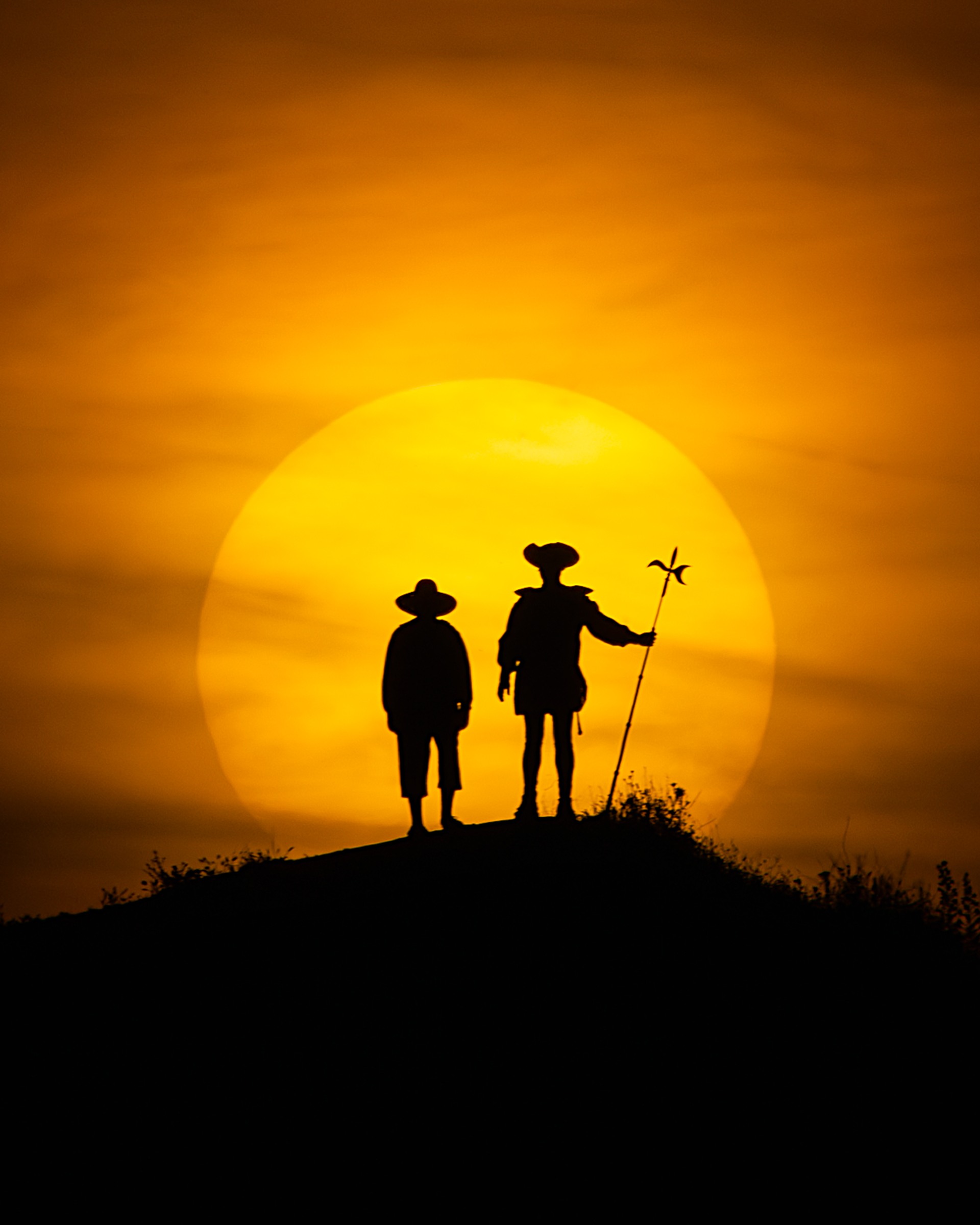 Dos personas en silueta delante del Sol al atardecer, fotografía de Chechu Senís