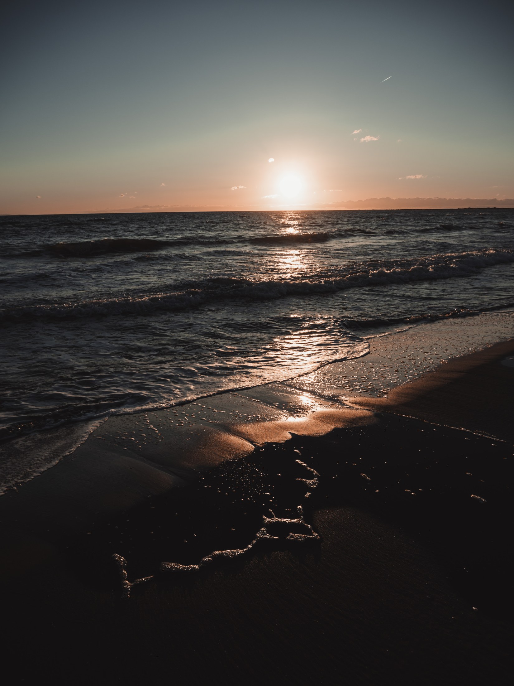 Puesta de sol sobre el mar vista desde la orilla