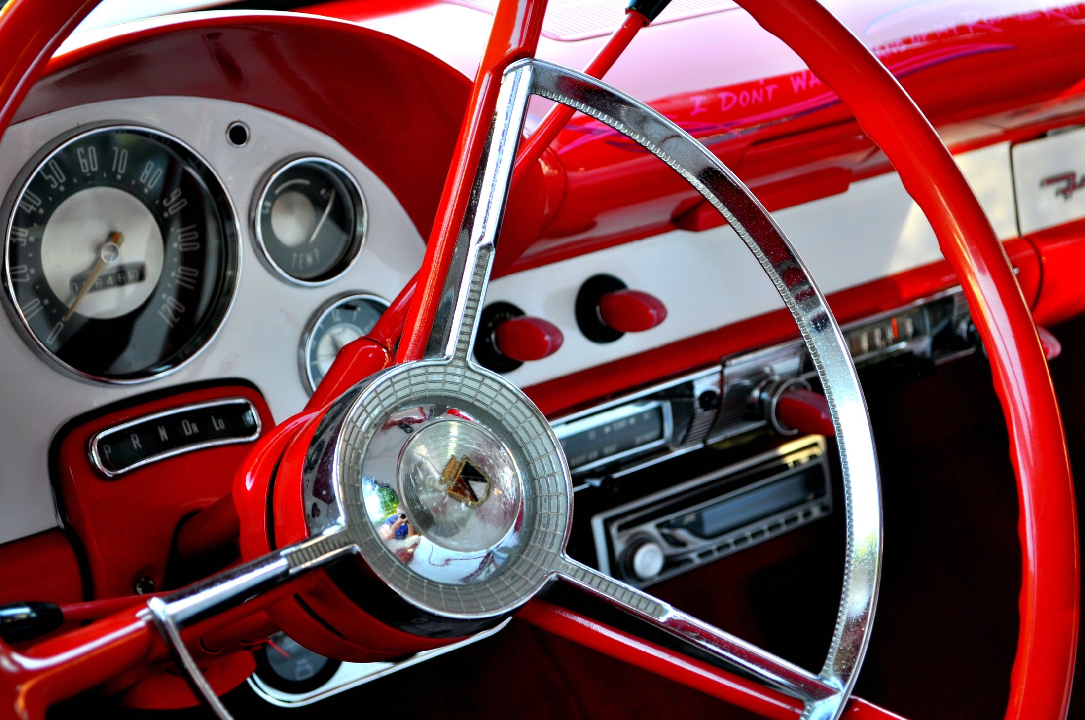 Detalle del volante y salpicadero rojo de un coche clásico