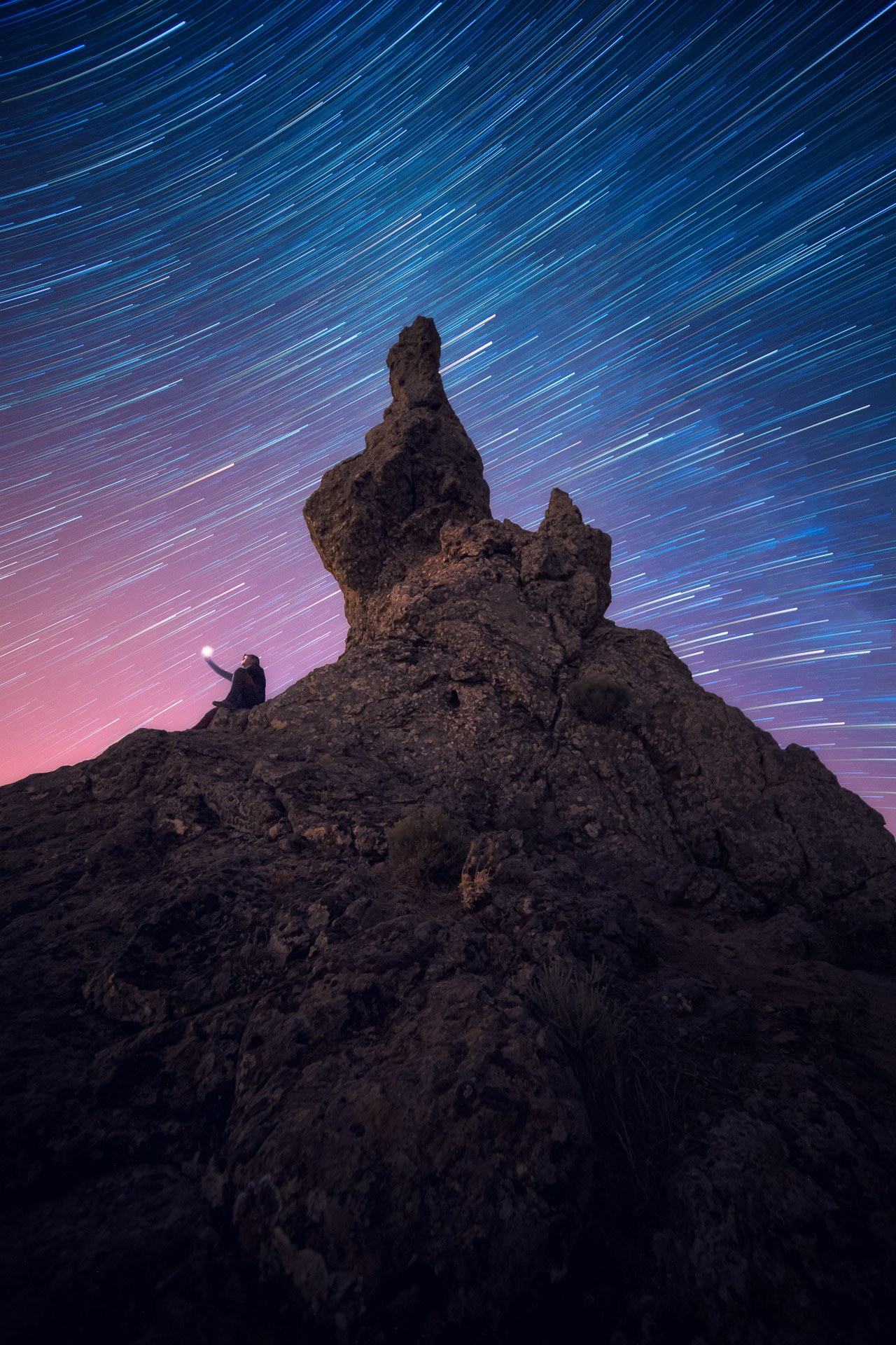Figura junto a un roque bajo trazas estelares, fotografía de David Rodríguez