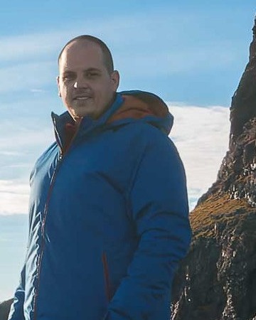 Retrato cercano de David Rodríguez en un paisaje de montaña